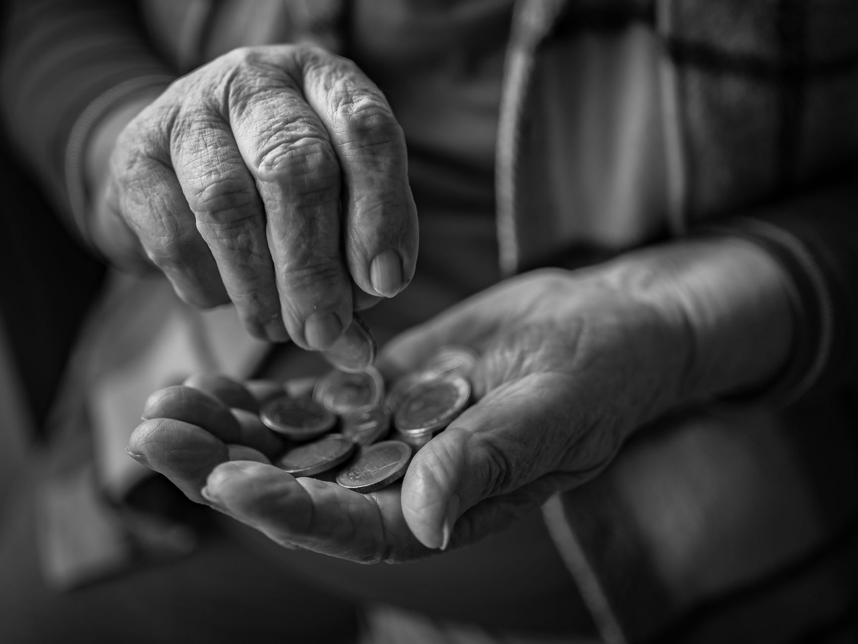Mâini bătrâne numărând indemnizație socială